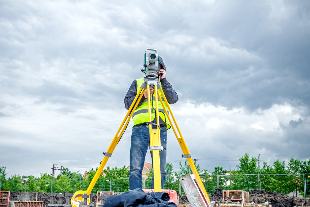 Surveyor,Engineer,Is,Measuring,Level,On,Construction,Site.,Surveyors,Ensure