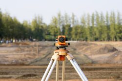 Surveyor's,Telescope,On,Site,With,Machine,Background